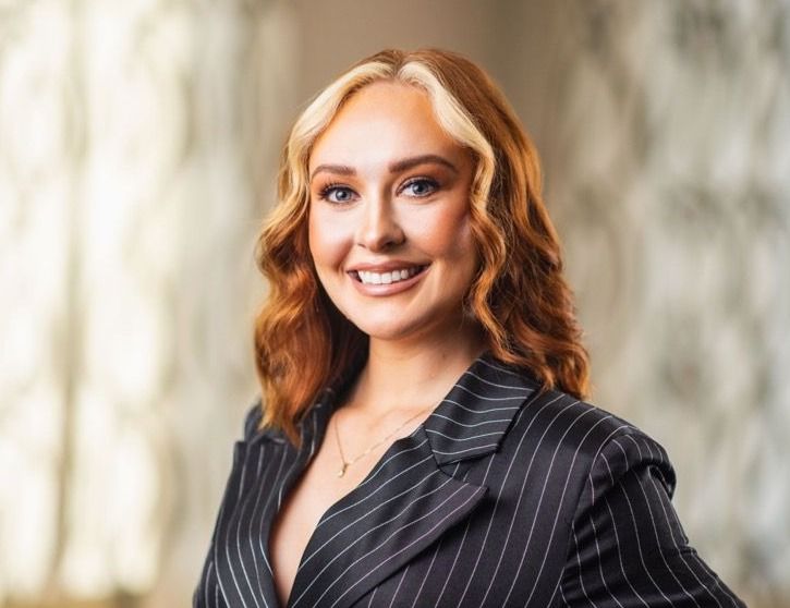 Smiling woman in a pinstripe suit.