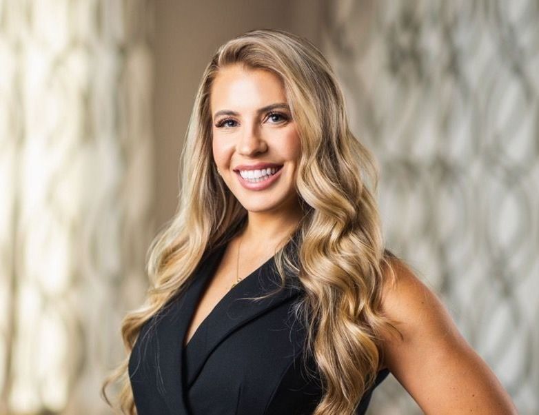 Smiling woman with long, wavy blonde hair.